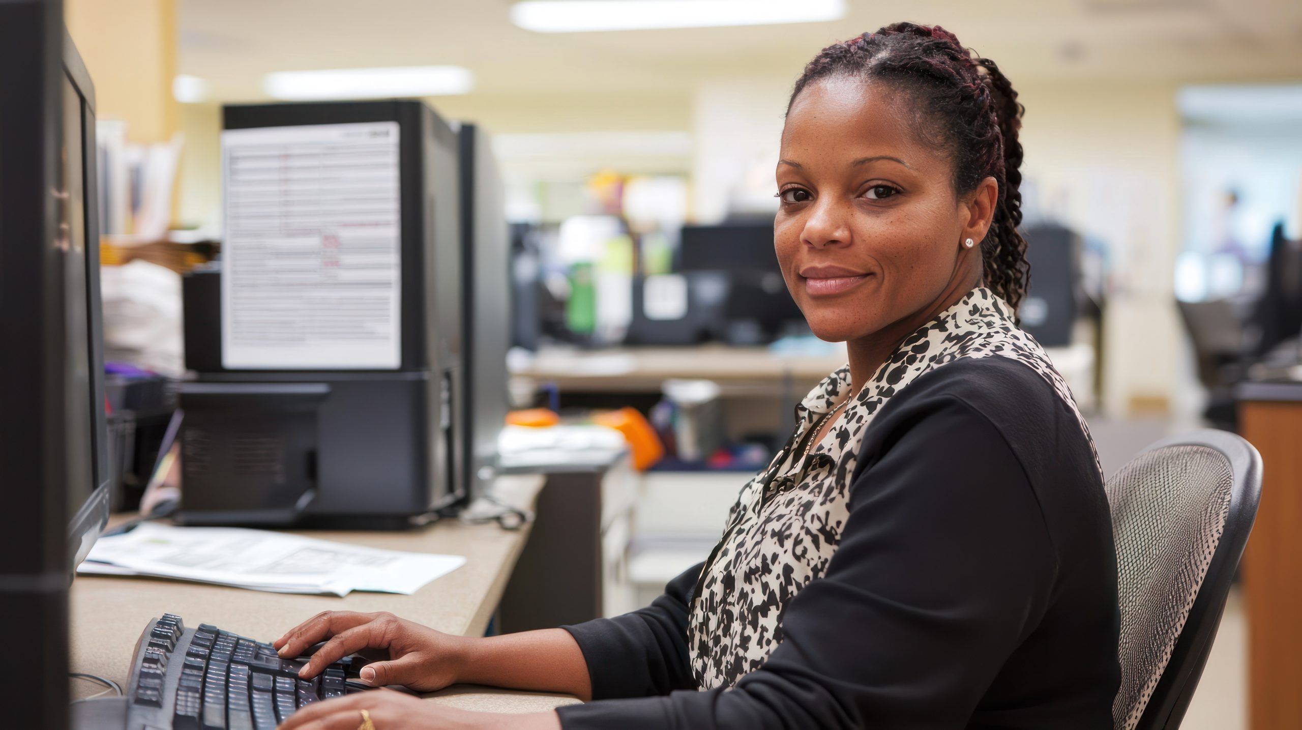Smiling woman at computer representing flexible online certificate programs