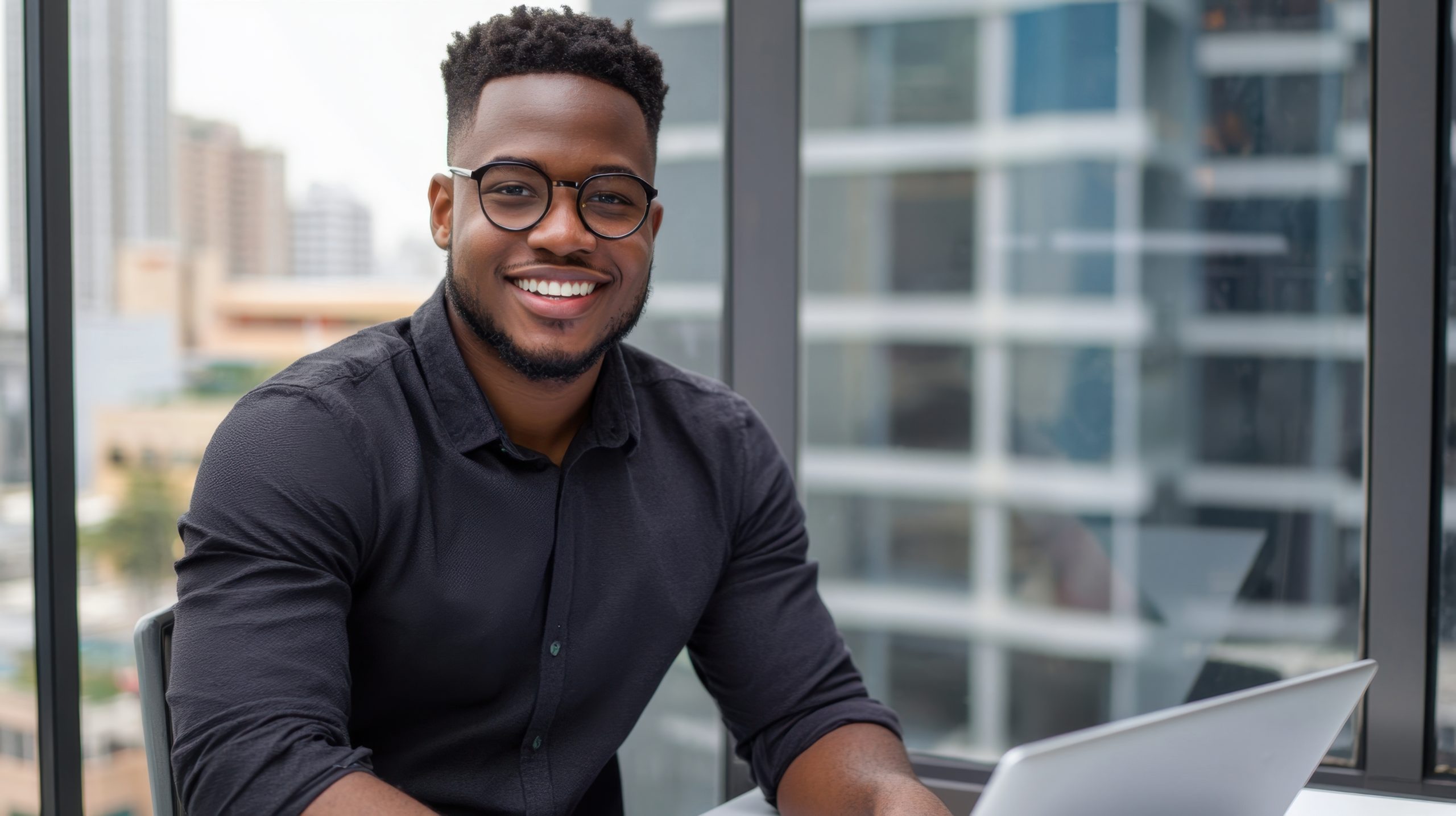 Confident graduate student with laptop in modern office setting