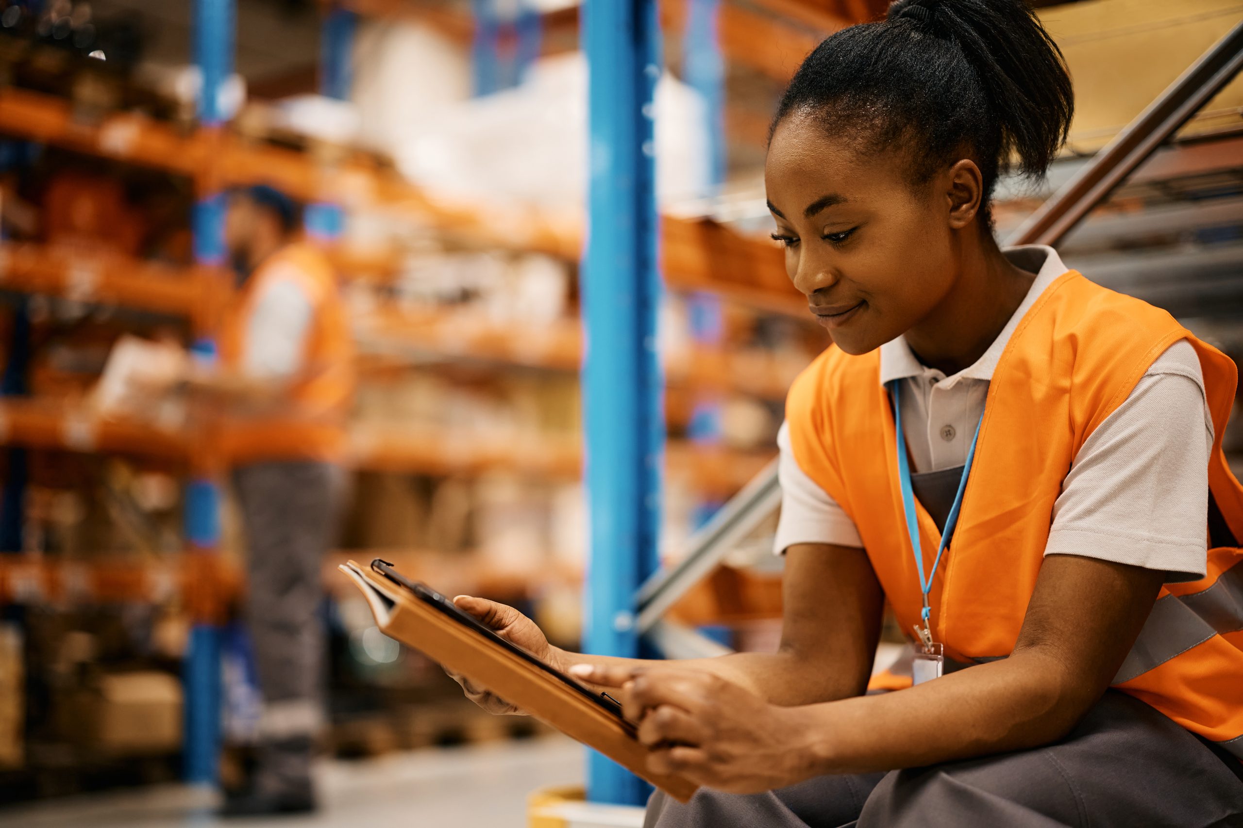 Female warehouse manager review supply chain details.