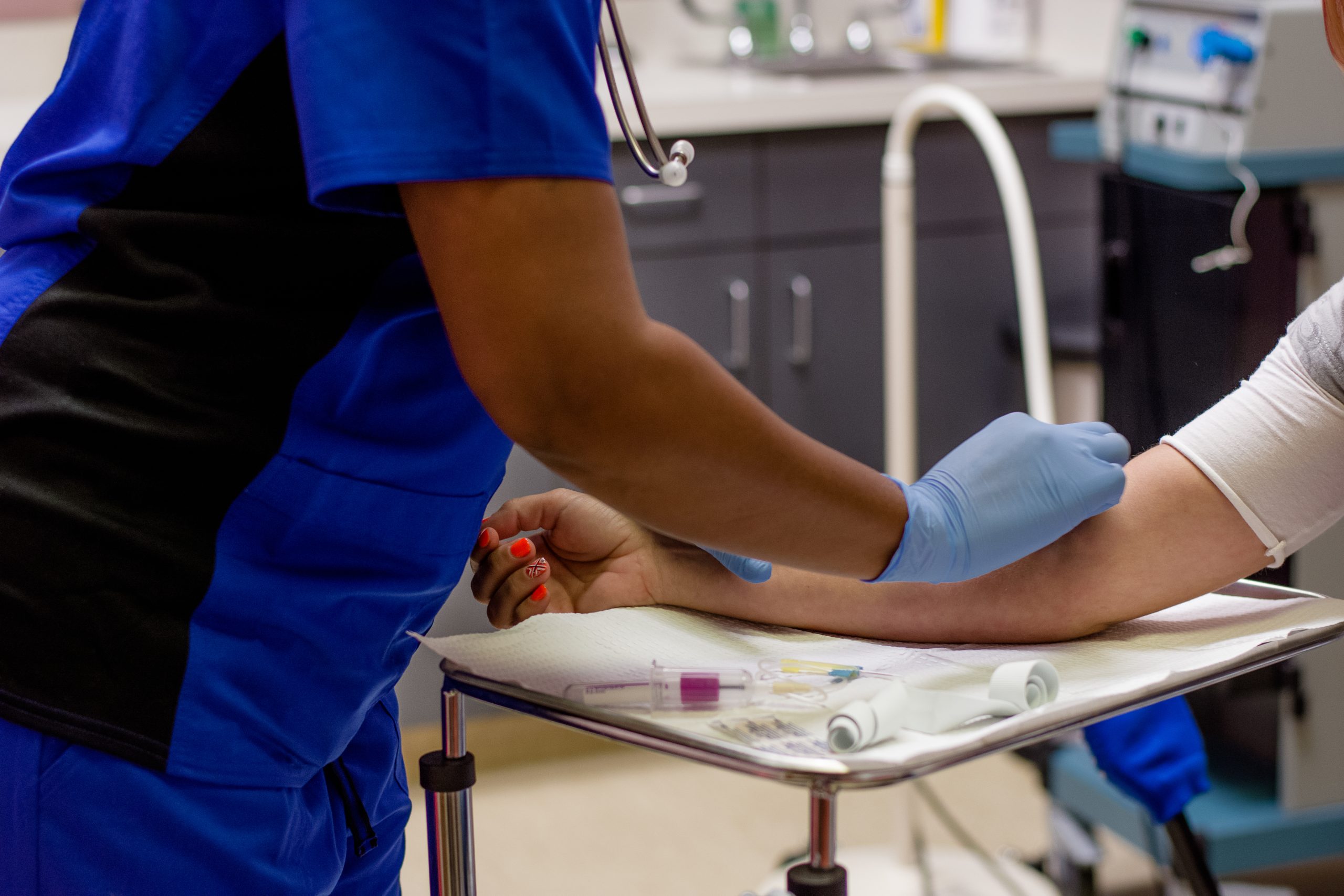 Phlebotomy technician drawing blood training lab