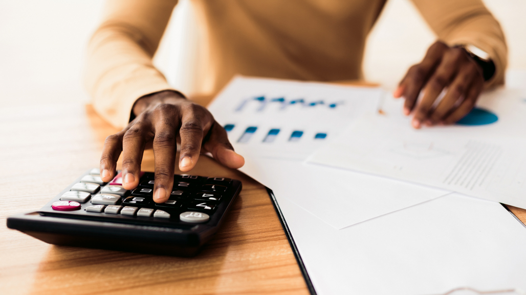 Student analyzing financial reports with a calculator for Delaware State University’s Bachelor of Science in Accounting program.