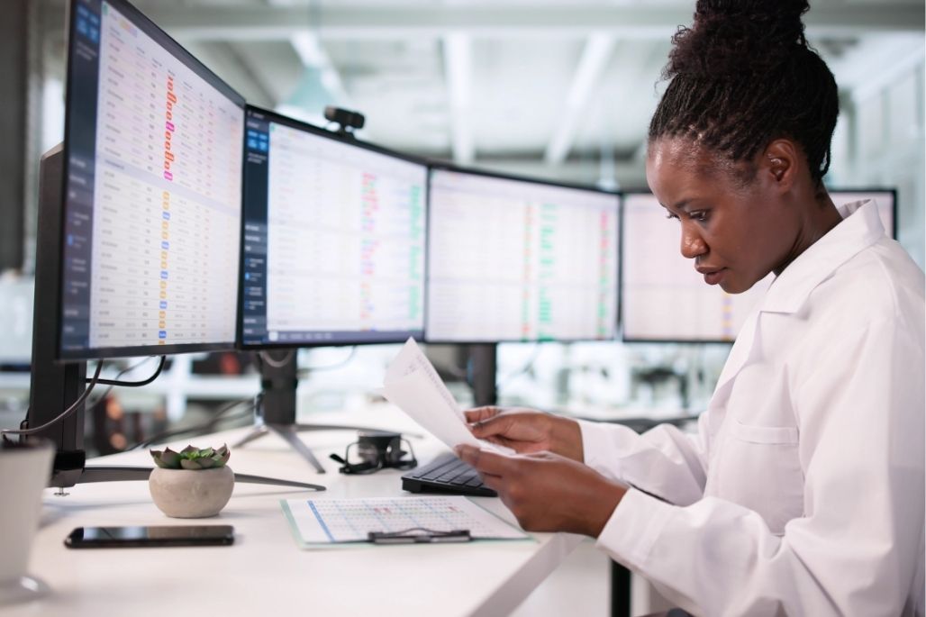 Electronic health records specialist entering patient data on a computer in a medical office.