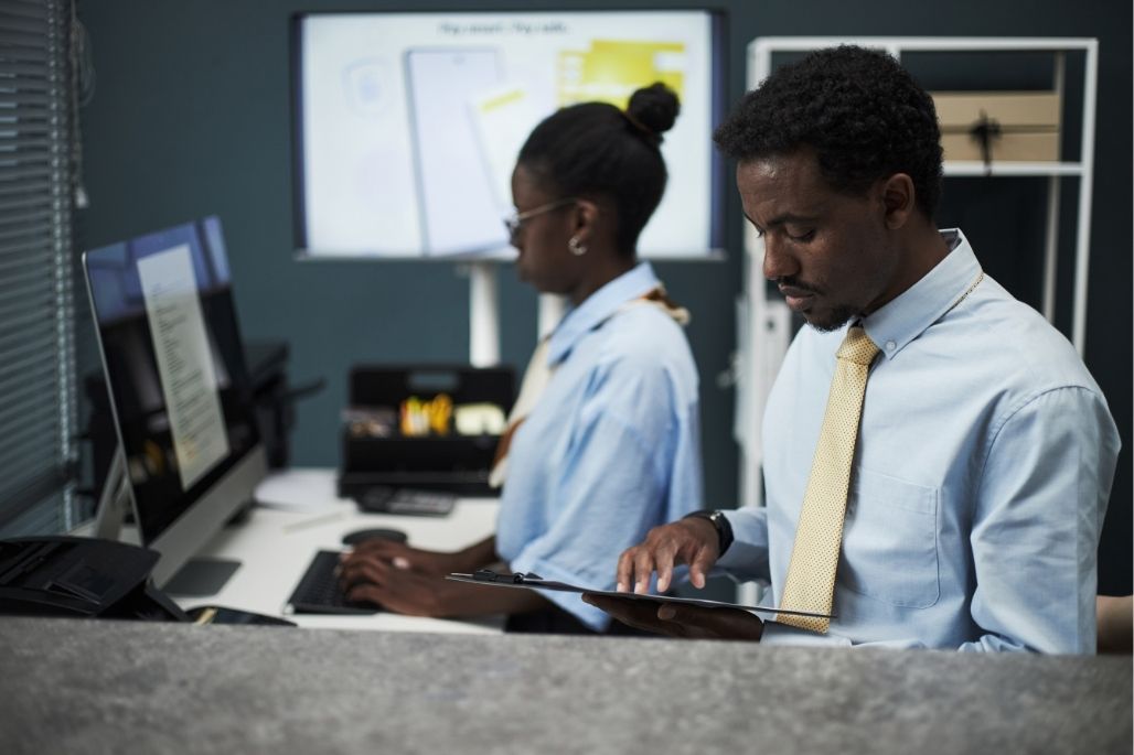 Electronic health records specialist entering patient data on a computer in a medical office.