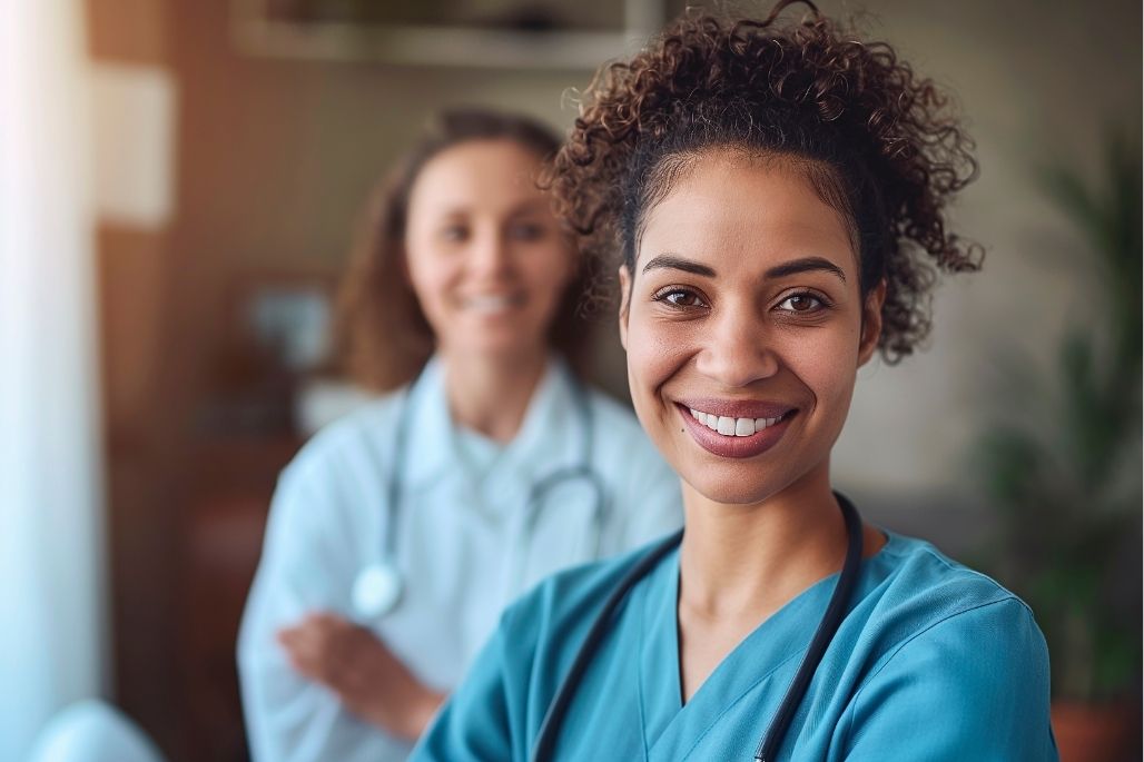 Geriatric medical assistant speaking with an older adult in a clinic.