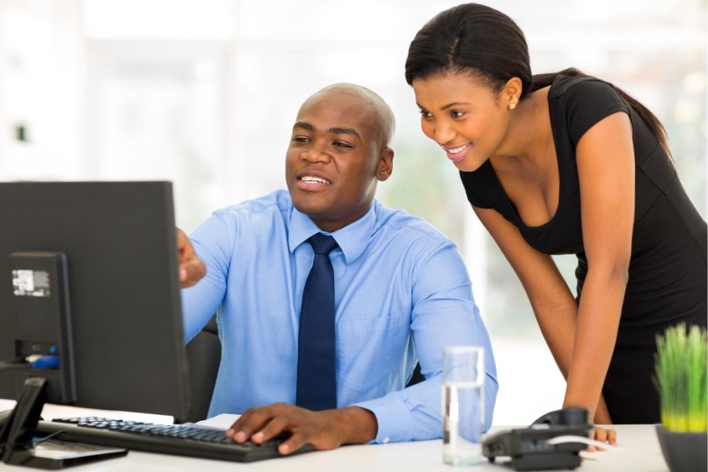 Electronic health records specialist entering patient data on a computer in a medical office.