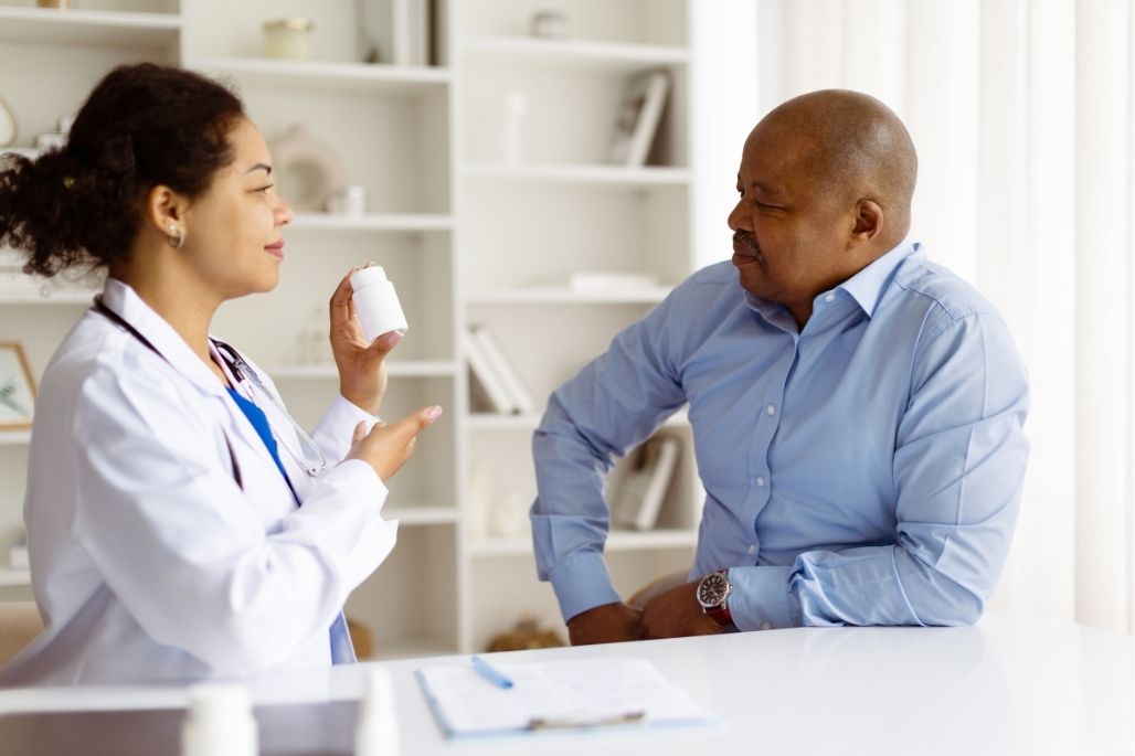 Medical office administrator reviewing patient files at a desk in a clinic.