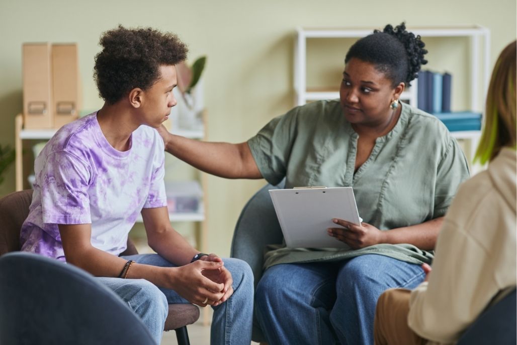 Mental health support professional counseling a patient in an office.