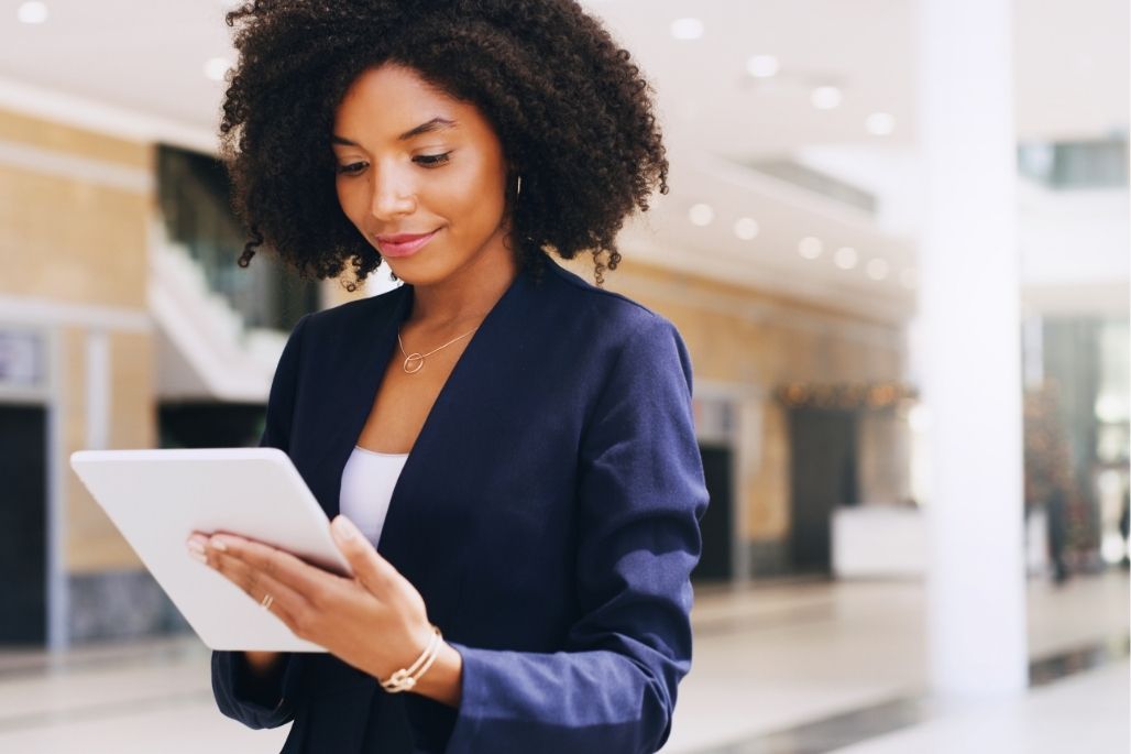 Project management student reviewing a plan on a laptop in an office.
